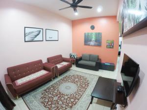 een woonkamer met 2 banken en een tv bij D HOMESTAY SERI ISKANDAR in Seri Iskandar