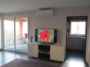 a living room with a flat screen tv on a table at Port Royal in Aix-en-Provence