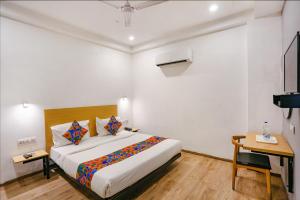 a hotel room with a bed and a desk at FabHotel Roseman in New Delhi