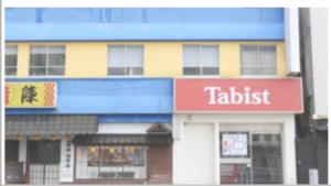 a tall building with a tadaisk sign on it at Tabist Hotel Miyakonojo Miyazaki in Miyakonozyō