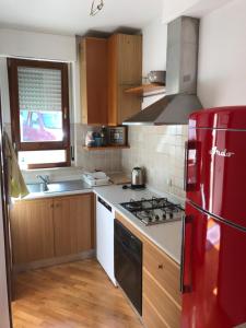 a kitchen with a red refrigerator and a sink at Il Ciliegio - House with Garden & Wonderful View in Pietra la Croce