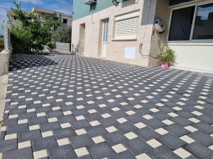 a house with a checkered concrete driveway at צימר נתיב המעיין in Ein Kinya