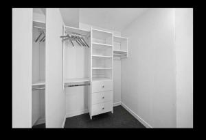 an empty closet with white cabinets and shelves at La Maison de Capitaine in Winnipeg