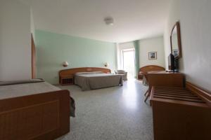 a hotel room with two beds and a television at Hotel Eden in San Domino +37 photos