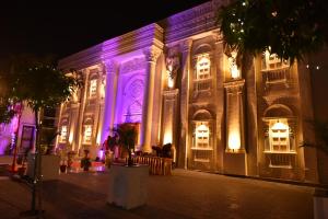 ein nachts beleuchtetes Gebäude mit lila Leuchten in der Unterkunft Hotel Yash Regency in Jaipur