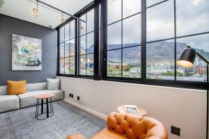 a living room with a couch and some windows at Luxury urban living at The Harri in Cape Town