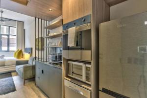 a kitchen with a microwave and a living room at Luxury urban living at The Harri in Cape Town