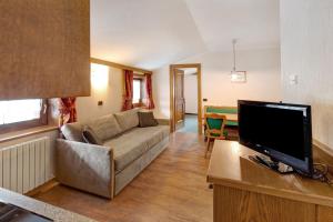 salon z kanapą i telewizorem z płaskim ekranem w obiekcie Casa San Marco n 8 w Livigno