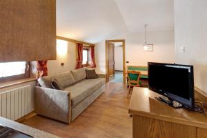 a living room with a couch and a flat screen tv at Casa San Marco n 8 in Livigno