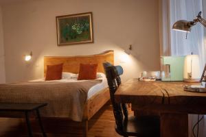 a bedroom with a bed and a table with a lamp at Elma Guesthouse in Alba Iulia