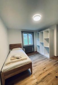 1 dormitorio con cama, suelo de madera y ventana en Ferienhaus Granula en Linthal
