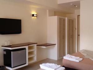 a room with a bed and a tv on the wall at Signature Boracay South Beach in Boracay +32 photos