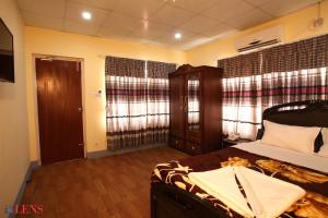 a bedroom with a bed and a window with curtains at Melungtse apartment in Kathmandu