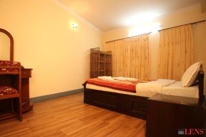a bedroom with two beds and a wooden floor at Melungtse apartment in Kathmandu