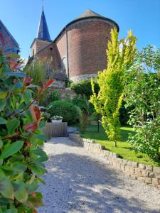 a garden in front of a building with a tower at Au pousseux d'église in Havay