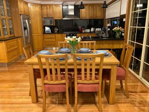 cocina con mesa de madera con sillas y comedor en Style/Comfort/Spacious 4 bedroom house plus study, en Melbourne