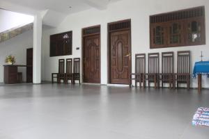 een kamer met drie houten deuren en een tafel en stoelen bij Eleven11 Resort in Anuradhapura