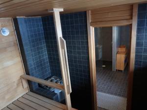 プーマラにあるOkkolan Lomamökitのバスルーム(青いタイル張りの壁のシャワー付)