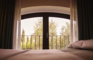 a bedroom window with a view of a balcony at Villa Acquaviva Wine Resort in Montemerano