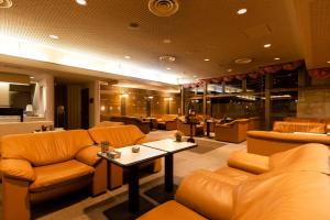 銚子市にある銚子プラザホテルのソファ、テーブル、椅子が備わる待合室