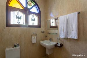 łazienka z umywalką, toaletą i oknem w obiekcie Al-Minar Hotel w mieście Zanzibar