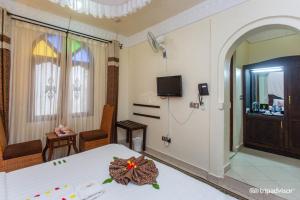 una camera da letto con un letto fiorito di Al-Minar Hotel a Zanzibar City