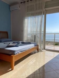 een slaapkamer met een bed en uitzicht op de oceaan bij Relax Rental in Vlorë