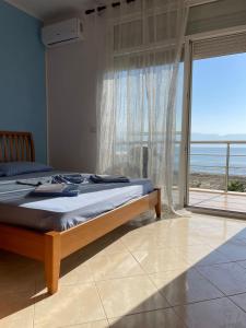 een slaapkamer met een bed met uitzicht op de oceaan bij Relax Rental in Vlorë