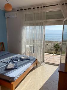 een slaapkamer met een bed en uitzicht op de oceaan bij Relax Rental in Vlorë