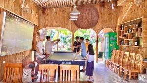 un gruppo di persone intorno a un tavolo da biliardo di Tam Coc Serene Bungalow a Ninh Binh