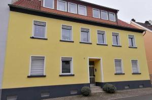 une maison jaune avec volets noirs dans l'établissement Gästehaus Schneider, à Neunkirchen