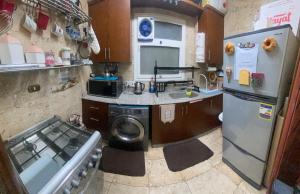 Your Home in Madinaty في Madīnat ash Shurūq: مطبخ صغير مع حوض وثلاجة