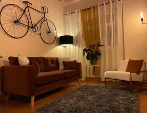 a living room with a couch and a bike on the wall at Logis Hôtel Le Saint Florent in Mont-près-Chambord