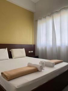 ein Schlafzimmer mit einem Bett mit zwei Handtüchern darauf in der Unterkunft Travelers Inn Matina in Davao City