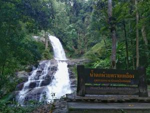una cascata in una foresta con un cartello di fronte di Cactus Hostel a Chiang Mai Altre 17 foto