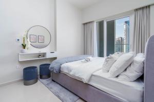 Delightful 2BR apartment at Reva Residences في دبي: غرفة نوم بسرير مع نافذة ومرآة