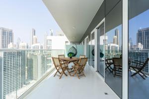 a balcony with a table and chairs on top of a building at Delightful 2BR apartment at Reva Residences in Dubai