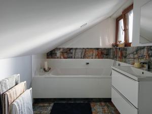 Baño blanco con bañera y lavamanos en Barytowy apartament, en Tarnowskie Góry