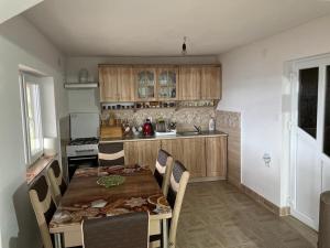 a kitchen with a wooden table and chairs and a kitchen with at Cabana Trif in Arada