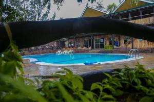 a large swimming pool in front of a house at Dovenest Lodge in Naivasha