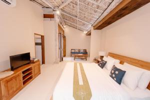 a bedroom with a large bed and a television at Moson Villa Legian in Seminyak