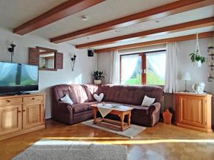 sala de estar con sofá marrón y TV en Ferienwohnung Haindorfer Berg, en Aschau im Chiemgau