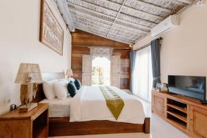 Un dormitorio con una cama y un televisor. en Moson Villa Legian, en Legian