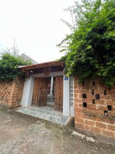 un edificio in mattoni con due porte e un albero di Đường Lâm Village a Sơn Tây