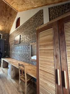 un tavolo in legno in una stanza con muro di mattoni di Đường Lâm Village a Sơn Tây