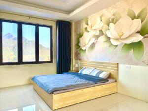 1 dormitorio con 1 cama con un mural de flores en la pared en The 1996 House, en Lào Cai