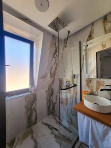 uma casa de banho com um lavatório e um chuveiro em Aurora Hills Hotel em Plovdiv