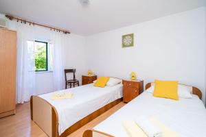 a bedroom with two beds and a window at Apartments Lidija in Zaton