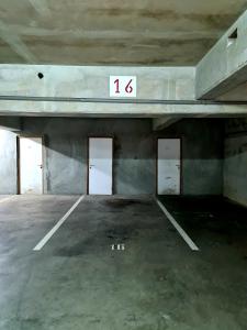 un estacionamiento vacío con cuatro puertas en un edificio en Farerei Appartement spacieux, équipé et confortable en Faaa
