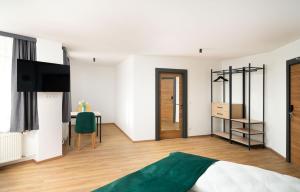 a bedroom with a bed and a desk with a television at DIWOTEL l RÜSSELSHEIM in Rüsselsheim